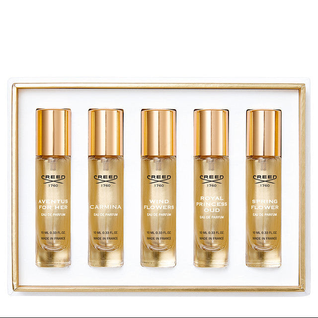 Set of five Creed perfume bottles in a gold frame on a white background